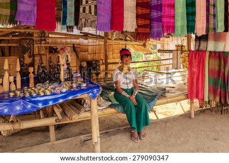 Chiang Mai, Thailand - April 24, 2009: A  lady waits for customer at her stall selling traditionally woven scarfs. The Karen tribe ladies are known to wear brass neck rings to extend the neck.