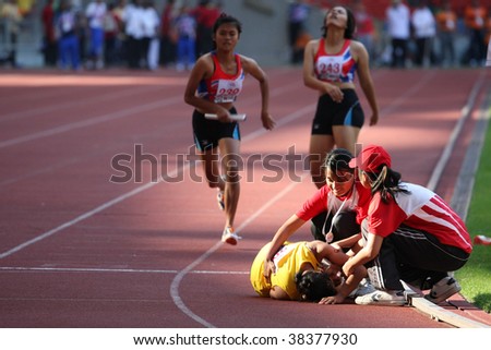 KUALA LUMPUR - AUGUST 18: Malaysia\'s visually impaired relay team runner falls after her run at the track and field event of the fifth ASEAN Para Games on August 18, 2009 in Kuala Lumpur, Malaysia.