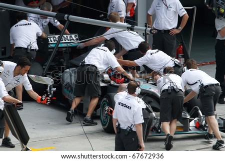 KUALA LUMPUR - APRIL 2: Mercedes\' mechanics push Michael Schumacer\'s car back into the garage on practice day at the 2010 Petronas Malaysia F1 Grand-Prix on April 2, 2010 in Sepang, Malaysia.
