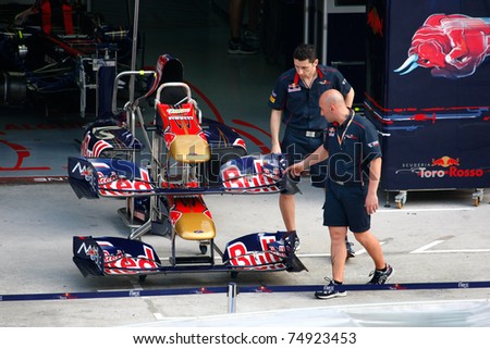 SEPANG, MALAYSIA - APRIL 8:  Scuderia Toro Rosso Team mechanics inspect the nose and wings of their race cars in preparation for the Petronas Malaysian F1 Grand Prix on April 8, 2011 Sepang, Malaysia.