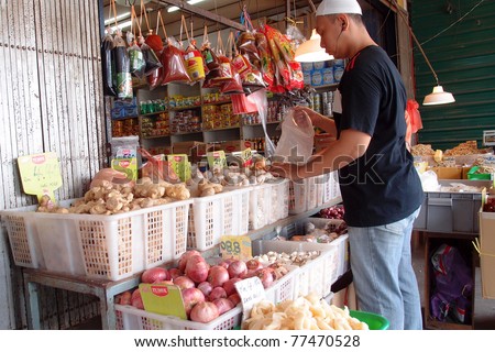KUCHING - MAY 13: An unidentified man packs the fruits at his grocery shop in town, May 13, 2011 in Kuching, Borneo Island. Most of the shops cater to the town-folks and a growing number of tourists.