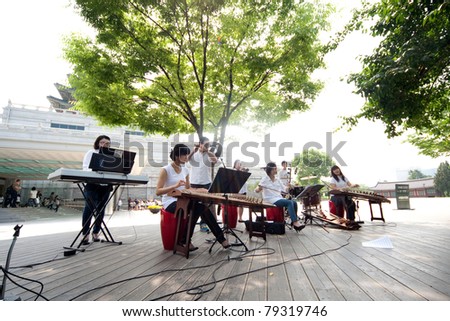 SEOUL - JUNE 09: Musicians play traditional Korean musical instruments outside the National Folk Museum on June 09, 2011 in Seoul, South Korea. They help preserve the rich heritage of Korean music.