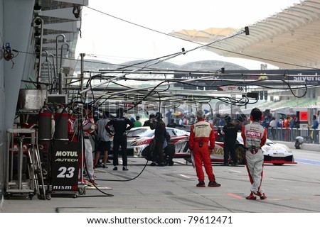 SEPANG - JUNE 19: Team mechanics working in the pitlane during the qualifying sessions of the Japan SUPER GT Round 3 at the Sepang International Circuit on June 19, 2011 in Sepang, Malaysia.