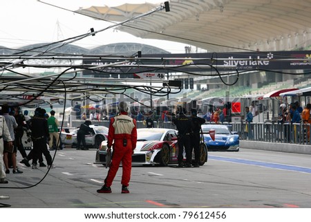 SEPANG - JUNE 19: Team mechanics working in the pitlane during the qualifying sessions of the Japan SUPER GT Round 3 at the Sepang International Circuit on June 19, 2011 in Sepang, Malaysia.