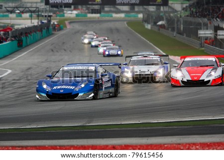 SEPANG - JUNE 19: Cars take off from a rolling start at the Japan SUPER GT Round 3 race at the Sepang International Circuit on June 19, 2011 in Sepang, Malaysia. The GT500 cars start in the front.