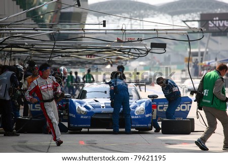 SEPANG - JUNE 19: Pit crew works on Team Impul\'s Nissan GT-R R35 car during the practice round of the Japan SUPER GT Round 3 race on June 19, 2011 in Sepang international Circuit, Malaysia.