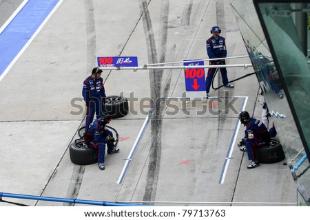 SEPANG - JUNE 19: Team Kunimitsu\'s pit-crew prepares for car to refuel, driver and tire change during the Japan SUPER GT Round 3 race on June 19, 2011 in Sepang International Circuit, Malaysia.