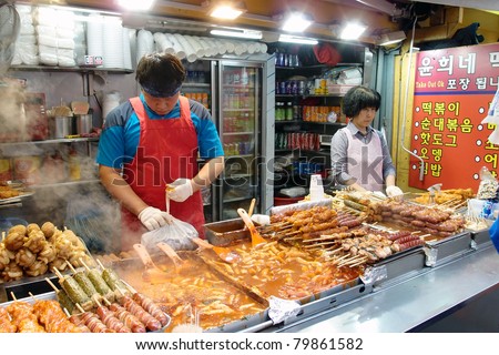SEOUL - JUNE 06: Workers at a street food stall in Myeungdong packs food items selected by customers on June 06, 2011 in Seoul, South Korea. This area is a famous shopping area for locals and tourists
