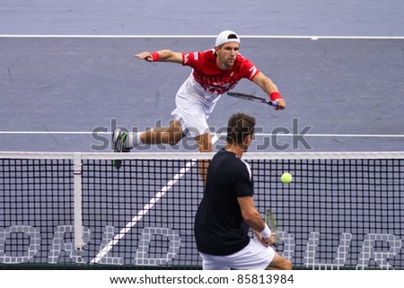 BUKIT JALIL - OCT 01: Jurgen Melzer (red) volleys in this Malaysian Open semi-final doubles game partnering Petzschner against Cermak/Polasek on Oct 01, 2011 in Putra Stadium, Bukit Jalil, Malaysia.