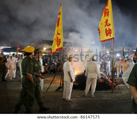 AMPANG, MALAYSIA – OCT 05: Taoist devotees walk bare-footed over the fire-pit at the Lam Thian Kiong Temple celebrating the annual ‘Nine Emperor Gods’ Festival on October 05, 2011 in Ampang, Malaysia.
