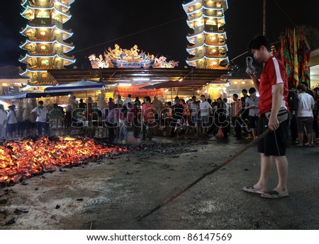 AMPANG, MALAYSIA – OCT 05: Devotees collect the charcoal believed to be blessed after the fire-walk at the Lam Thian Kiong Temple during the ‘Nine Emperor Gods’ Festival on October 05, 2011 in Ampang, Malaysia.