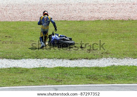 SEPANG, MALAYSIA - OCTOBER 23: Moto2's Mike di Meglio runs to his bike after a fall at turn 15 during warm-up at the Shell Advance Malaysian Motorcycle GP 2011 on October 23, 2011 at Sepang, Malaysia.