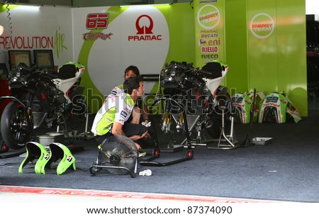 SEPANG, MALAYSIA - OCTOBER 21: Pramac Racing Team mechanics service Loris Capirossi\'s bike after the practice run of Day 1 of the Malaysian Motorcycle GP 2011 on October 21, 2011 at Sepang, Malaysia.