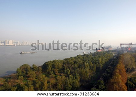 Barges and ships transport goods on the Yangtze River in Nanjing city in China.