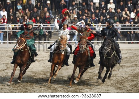 WUXI, CHINA - NOVEMBER 25: Knights on horseback fight out an ancient war in an outdoor theatre on November 25, 2011 in Wuxi, China.The scene portrays the war of the three kingdoms from 220AD to 280AD.