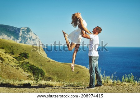 Stunning sensual outdoor portrait of young stylish fashion couple kissing in summer
