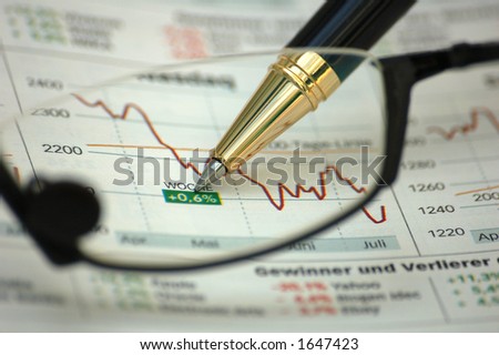Financial report through reading glasses - focus on pen and report (not on glasses)