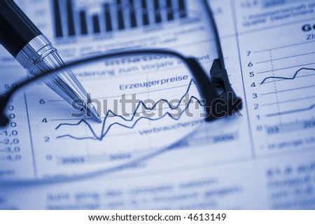 Pen on financial report (through reading glasses, focus on pen and diagram) (blue tone)