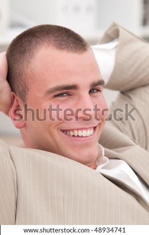 businessman relaxing in his office with a satisfied expression on his face
