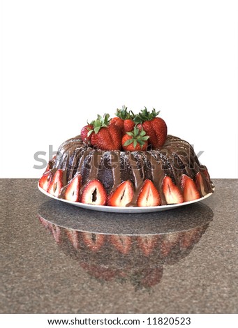 Chocolate bundt cake with fresh strawberries. Shot on granite with reflection. Background dropped out.