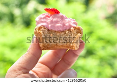 Bitten strawberry cupcake hold in hand