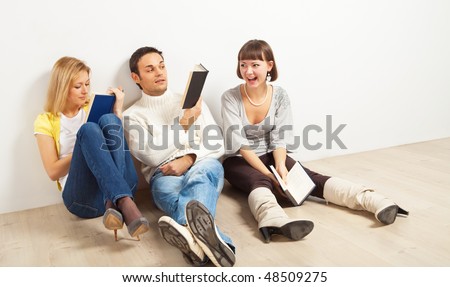 Three kidding students with books - one man and two women