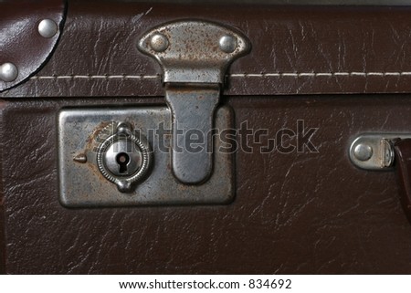 Lock on an old leather look suitcase.