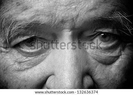 old man face part closeup eyes looks at camera monochrome image