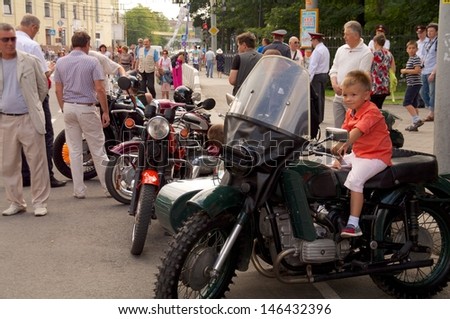 KALININGRAD, RUSSIA - JULY 14: boy sit on retro bike Ural on street on City Day of Kaliningrad celebration on July 14, 2013 in Kaliningrad, Russia