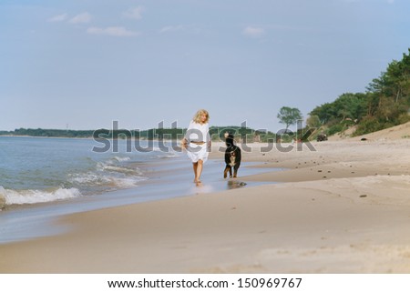 bernese mountain dog and woman walks near sea