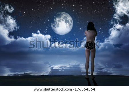 naked girl on sea beach looking at moon