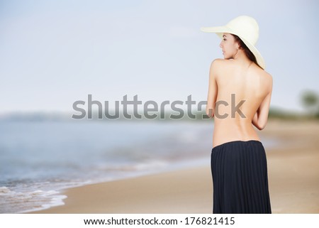 bared girl in hat on sunny sea beach