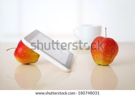apples, tablet pc and coffee cup on table