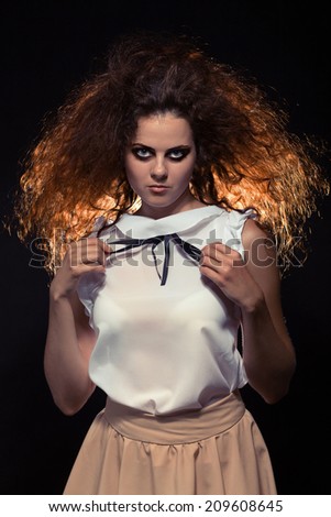 serious crazy woman with fluffy hair looking at camera. Toned image
