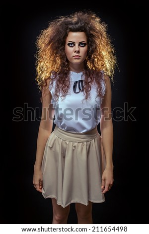 serious crazy woman with fluffy hair looking at camera