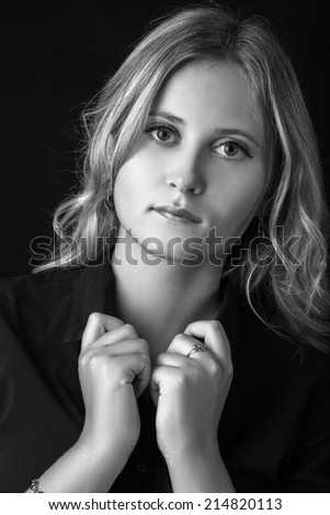 pretty blond girl in black blouse at dark, monochrome image