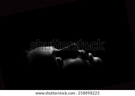 young female face profile with closed eyes in dark, monochrome