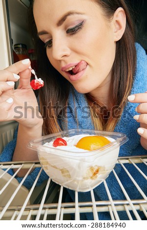 woman eating dessert inside refrigerator