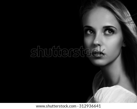 luxury scared blond girl on black background with copyspace, monochrome