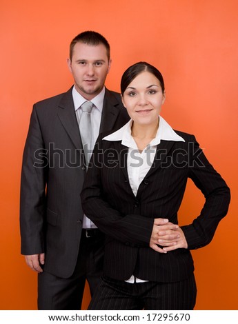 woman and man in team standing on orange background