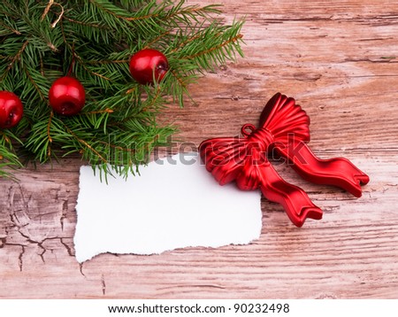 Christmas wreath made from fresh spruce branch and red ornaments on old wooden background
