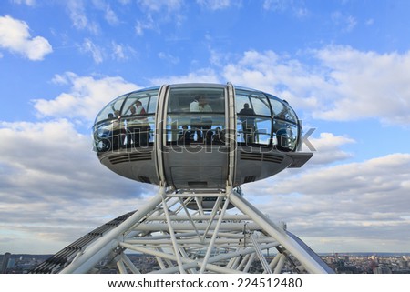 London, United Kingdom - September 26: Tourists look out from a pod as the London Eye reaches its zenith on September 26, 2014 in London, UK.