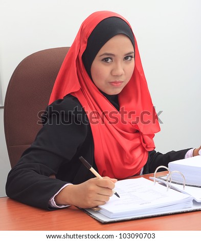 Beautiful young asian muslim business woman with serious face looking to the camera
