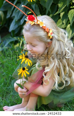 Happiness Is...  This little blond woodland fairy takes time to smell the flowers.  What makes you happy?