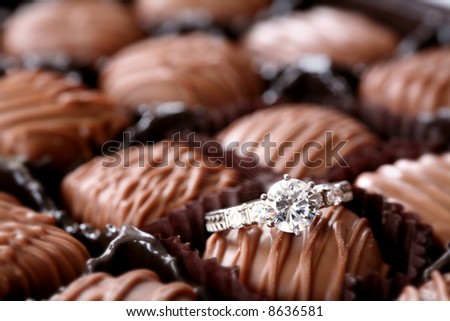 Sweet Surprise: You never know what you\'ll find in a box of assorted chocolates. Here, it\'s a diamond engagement ring. Love/valentine\'s day/romance concept.