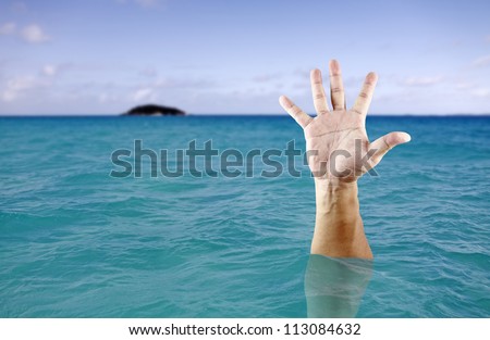 A hand of a drowning man stretch out from the deep blue sea.