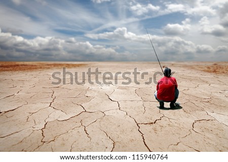 A patient angler fishing at a dried out lake for the concept of hoping for a better future.