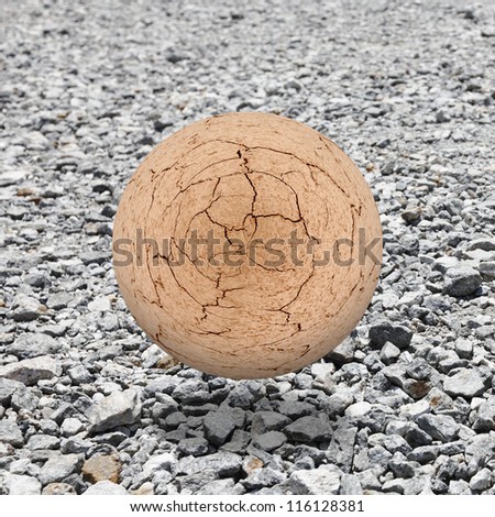 A cracking brown mud ball levitating above a granite rubble landscape for the concept of an apocalyptic future earth.
