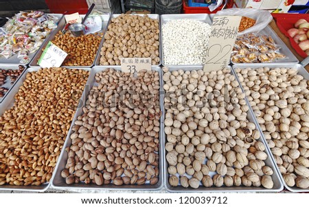 An assortment of nuts display on trays in a snack booth along the historical market street of Shantangjie, Suzhou, China.