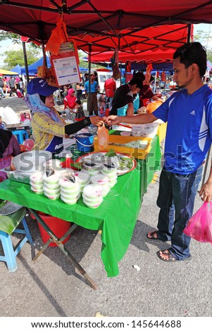 SHAH ALAM, MALAYSIA - JULY 11: A customer at a Ramadan food bazaar on July 11, 2013 in Shah Alam, Malaysia. The food bazaar is established for Muslim to break fast during the holy month of Ramadan.